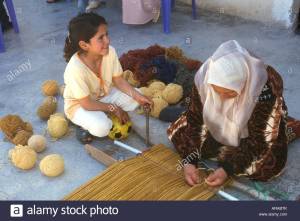 jordanian-village-woman-with-a-young-girl-helping-her-weave-wool-rug-ARABTK