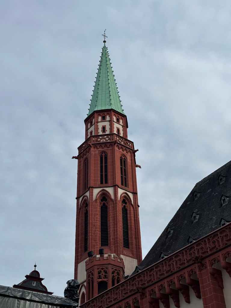 historic red brick church tower against blue sky